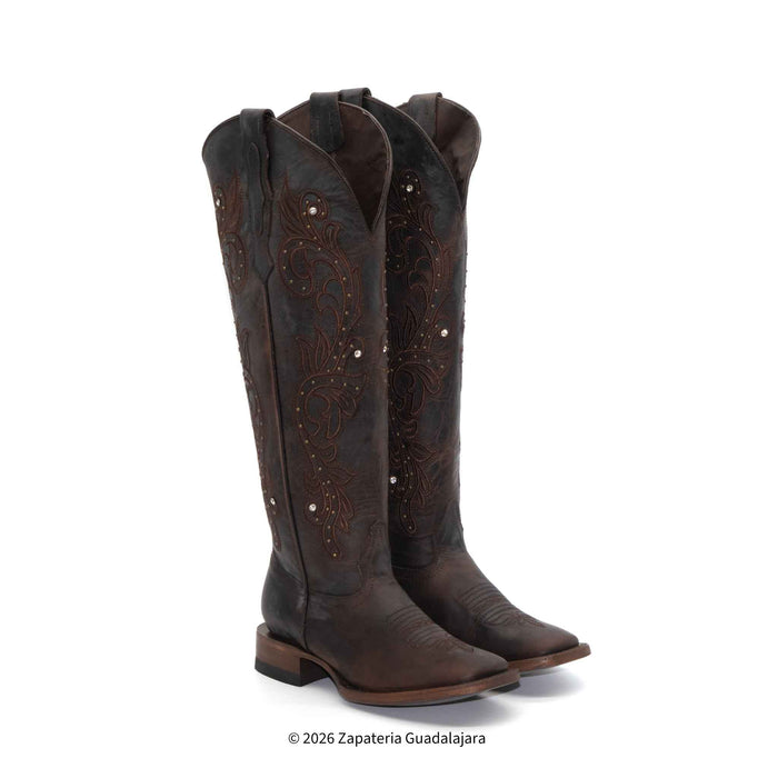 Pair of brown cowboy boots with intricate designs on a white background