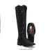Black cowboy boots with studded details on a white background