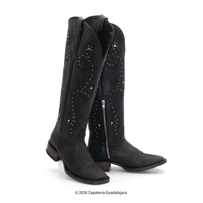 Black cowboy boots with decorative elements on a white background