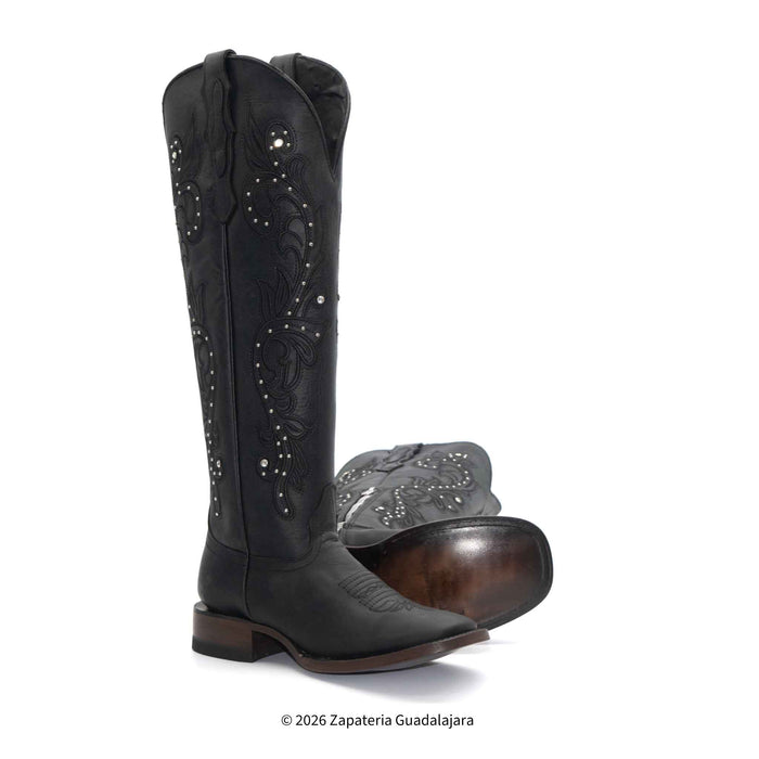 Black cowboy boots with decorative patterns on a white background