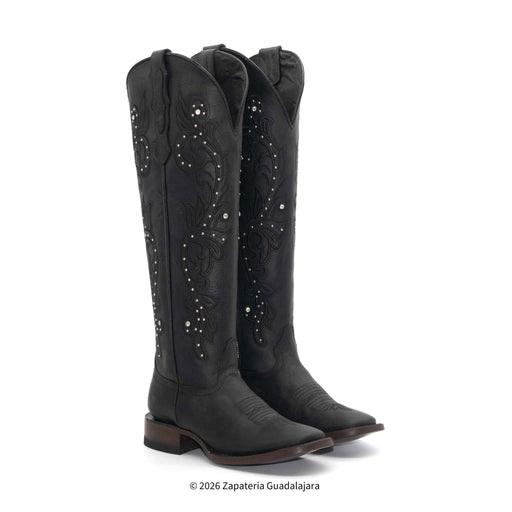 Pair of black cowboy boots with decorative patterns on a white background