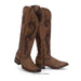 Brown cowboy boots with intricate designs on a white background