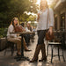 Woman in cowboy boots holding a coffee cup in an outdoor cafe setting