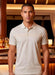 Man wearing a light-colored polo shirt in an indoor setting with warm lighting