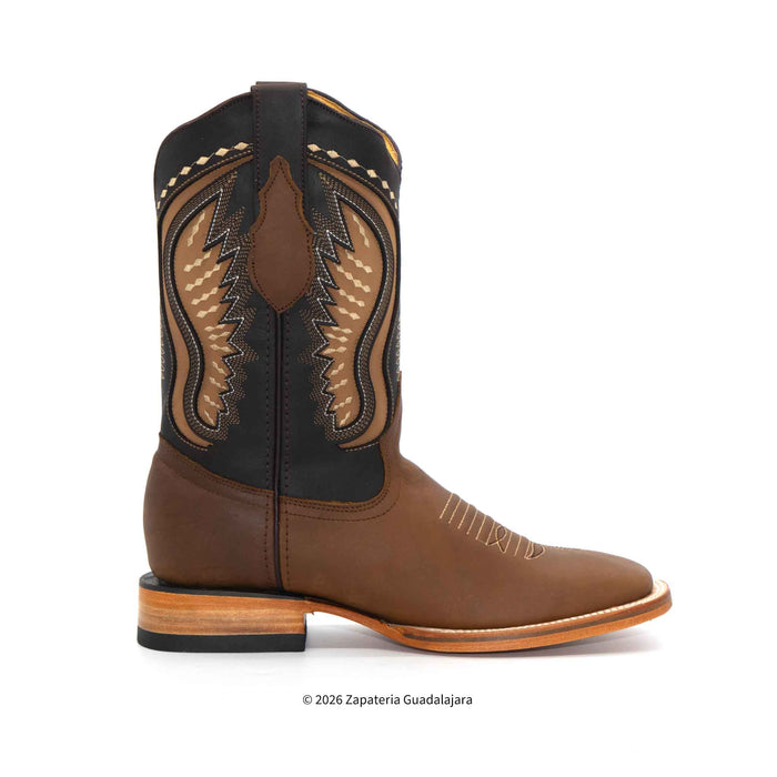 A brown leather cowboy boot with black and tan western embroidery on the shaft, shown in a side profile against a white background.