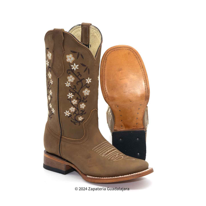 A brown leather western boot with floral embroidery on the shaft, shown alongside its tan outsole against a white background.